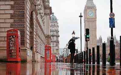  英国伦敦街头，雨中的撑伞者成为风景线 